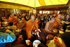The Sangha goes on rice pindapat around the cloister on Kathina day 2012. The light of the marquee casts a soft ocher light.