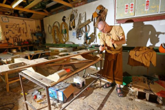 Ajahn Kusalo shaping the support posts for the board bearing the plaques to commemorate those who supported the construction of the kitchen.