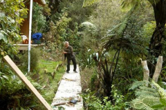 Ian about to launch a branch into the undergrowth as part of the tidy up around his kuti.
