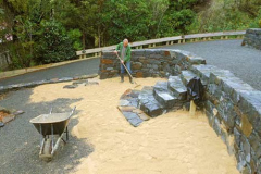 Adding yet another nice touch to his beautiful stone walled garden Simon rakes out the first layer of white stone.