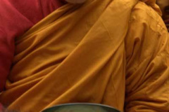 Receiving alms with focus and gratitude.