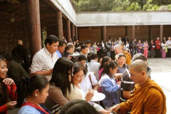 The Sangha going pindapat around the cloister with the community lined up three or more deep on all four sides.