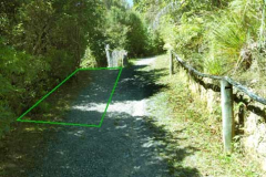 The track will be split just below the upper house to lower the very steep up-and-then-down on the longer loop track. The area in green will be removed.