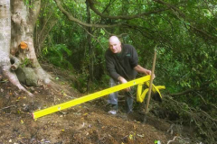John our kuti builder doing a quick site level check to order the foundation timbers.