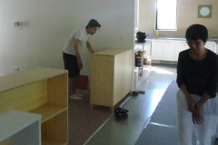 Ajahn Kusalos son (left) helps with the installing of the new cabinets. Suan is right.