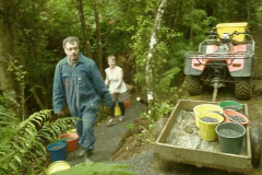 Peter and Clare carrying buckets along the new kuti track.