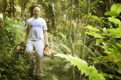 With a chainsaw in each hand James makes his way to the hermitage track.