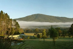 A warm morning sun lifts mist from the valley floor. This view from the main sala with the workshop left and dana sala out of view to right.