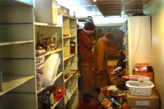 An empty shelf stands empty while Ajahn Ariyasilo and Venerable Hiriko ponder the fate of remaining remains in the Dhamma sala store.