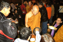 Ajahn Nantawat amidst the happy throng filling the cloister to offer rice pindapat.
