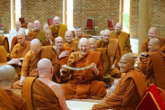 Ajahn Sumedho offering Ajahn Khemadhammo a robe.