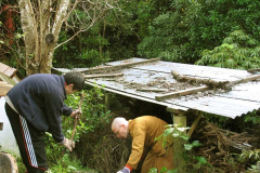 Venerable Aruno and Lam Nam tidying and adding to our firewood supply.