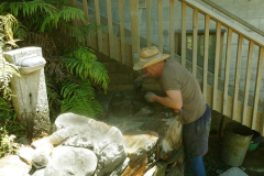 Simon applies the final grouting to the end of the stair wall. It is bright enough for a sun hat!
