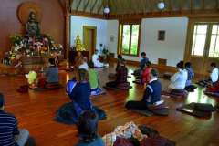 The retreat has almost ended. The Sangha chant blessings.