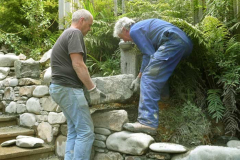 Simon and Gavin lifting a major stone onto the top of the new stairway wall. Built to last.