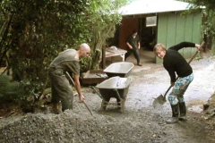 Julienne and Katie-Jayne shoveling gravel to go on the access track and service area under the workshop.