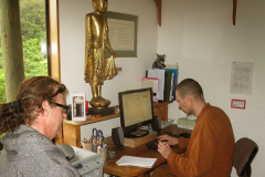 Venerable Kondanyo organising a flight for Ajahn Kongrit with Drew all ready as steward.