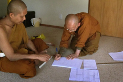 Ajahn Kongrit introducing venerable Kusalacitto to the craft of robe-making.