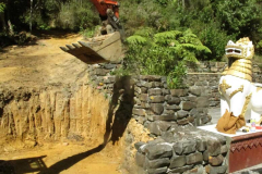 The digger about to remove the stone wall (in shadow). A face off between machine and dragon?