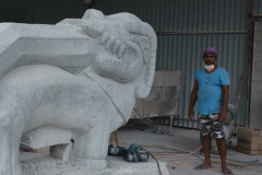 One of the workers next to a large makara (guardians - half terrestrial animal half aquatic). Safety gear was minimal with steel toe-cap boots optional.