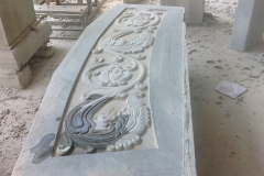 The entry step. The motif echoes the foliage band of the moonstone.