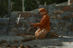 Ajahn Dta in the stupa forecourt setting a few level points for the digger. The clay is almost as hard as the rock.