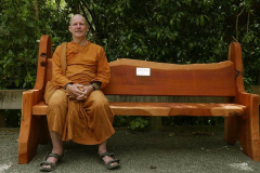 Ajahn Kusalo testing the new memorial bench in the sala courtyard.