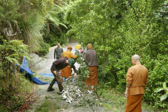 Vegetation trimmed from around the Chao Khun kuti is fed into the new mulcher.