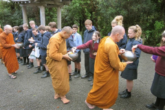 Children from Kapiti College offer alms.