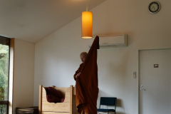10:25 am - lunch is an imminent possibility. Venerable Phasuko puts on his robe in preparation.