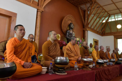 The Sangha has gathered in the Dhamma Hall and wait patiently for everyone to settle.