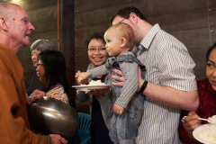 A young donor offers rice to Ajahn Kusalo.