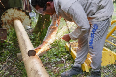 Beat cutting a section of pipe for drainage.