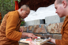 Stupa dedication: ajahn Dta adding relics at the base of the buddha rupa.