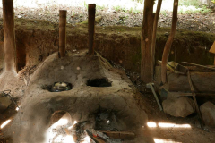An earthen oven used for both the kettle and for the (very) large bowl used for dye-washing robes. Note the bamboo chimneys.