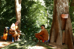 Aj Kusalo with the abbot learning how to strip palm fronds to make the material for broom making.