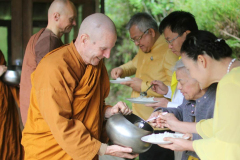 Bee: Embassy staff and friends offer pindapat to the Sangha.