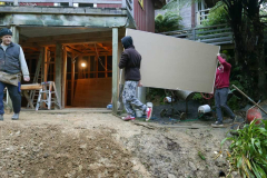 Cosmo and Ryan carrying the gib board down from the forecourt to the new Garden kuti.