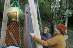 The concrete lotus bud being raised into position at the monastery front entrance.