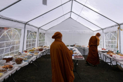 Monks receiving and sorting alms offerings. It was generally agreed that the new food tent was useful... you will see it again.