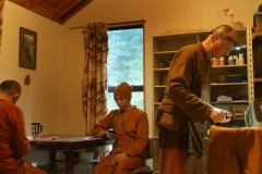 Ajahn Sambodhi works on the kathina robe borders. Ajahn Sudhiro works on - his phone :)
