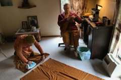 Ajahn Kusalo trying to remember how to do a french seam. Venerable Kusalacitto prepares the two pieces of the kathina robe ready for joining.