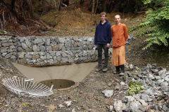 Venerable Buddhisaro and Sam putting the last touches to the landslide sump apron as part of the vihara concrete pour.