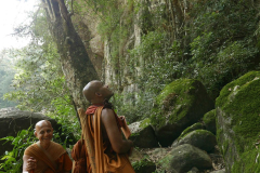 Ajahn Damita looks upward in disbelief. "That is not an impassable cliff..." Venerable Sumangala can see the funny side. We are lost.