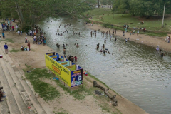 Ritual bathing in the river. Katragama temple in the background.