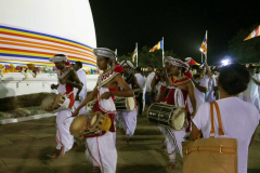 Traditional drummers circumambulate the stupa.