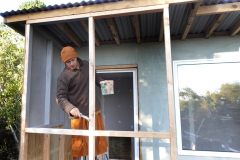 Venerable Dhammavasa applying the first coat to the new kuti porch frame. This panel will eventually be sheathed with clear acrylic sheet.