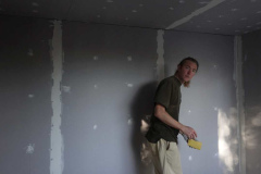 Joshua working on the plastering of the new monk kuti.