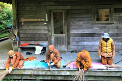 A broom making session at the back of the sala.