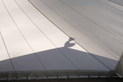The new cloister canopy in the early morning sun. The sala roof-rooster casts a shadow.